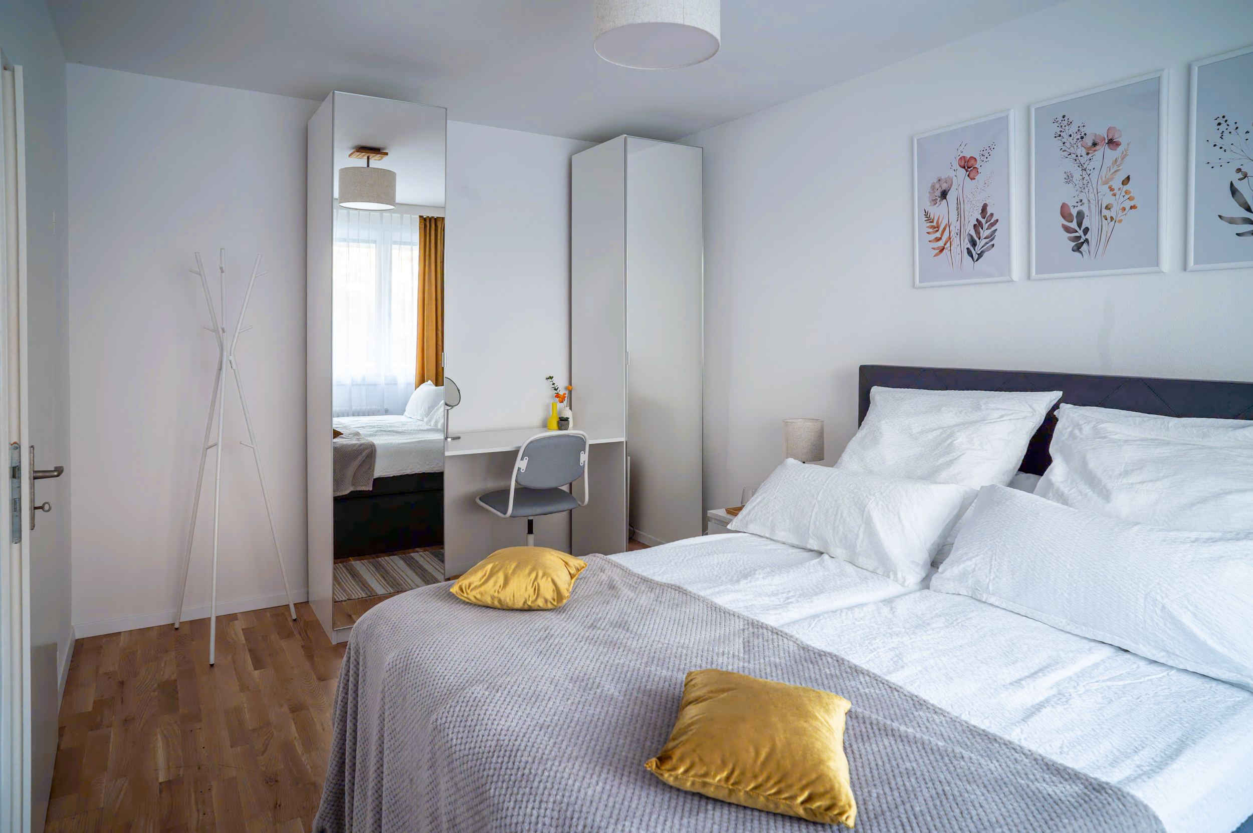 Schlafzimmer im EXPO Basel Apartment mit Doppelbett, Kleiderschrank und Schreibtisch