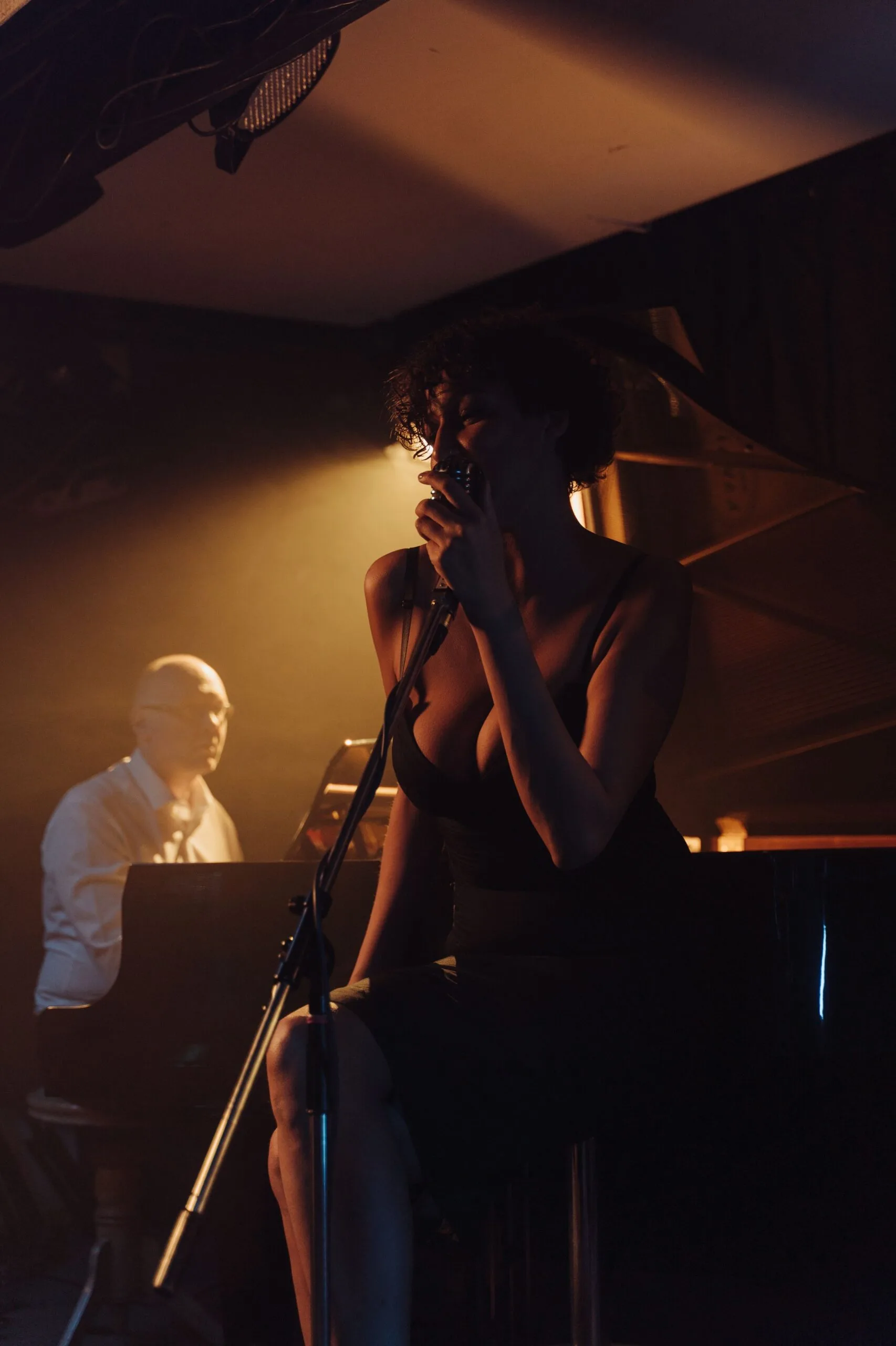 Sängerin in schwarzem Kleid unter warmem Bühnenlicht bei einem intimen Konzert